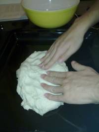 On étale la pâte à la main sur toute la surface