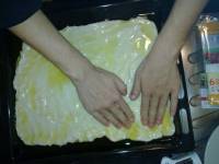 On étale la pâte à la main sur toute la surface