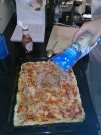 On badigeonne la pâte avec le ketchup, on place le fromage râpé