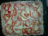 On complète la pizza avec les rondelles de tomate, les dés de poivrons et l'origan